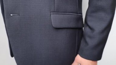 Takım elbisenin cebine yakın çekim, cebine para koymak. El cebe para koyar, rüşvet verir. Yüksek kalite 4K görüntü.