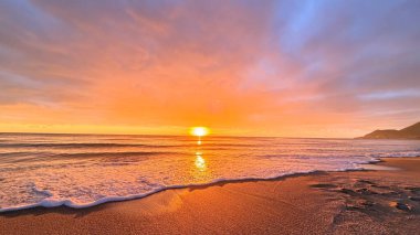 Sahilde günbatımı. çarpıcı renkli gökyüzü, deniz manzarası. Yüksek kalite 4k görüntü