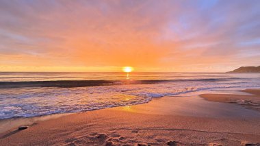 Sahilde günbatımı. çarpıcı renkli gökyüzü, deniz manzarası. Yüksek kalite 4k görüntü