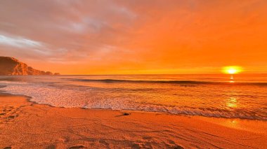 Sahilde günbatımı. çarpıcı renkli gökyüzü, deniz manzarası. Yüksek kalite 4k görüntü