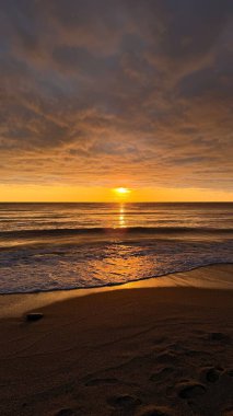 Sahilde günbatımı. çarpıcı renkli gökyüzü, deniz manzarası. Yüksek kalite 4k görüntü