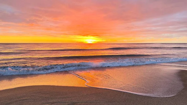 Sahilde günbatımı. çarpıcı renkli gökyüzü, deniz manzarası. Yüksek kalite 4k görüntü