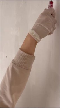 Duvarı boyayan kişi. Bir ressam silindirle beyaz bir duvar boyuyor. Yüksek kalite 4k görüntü