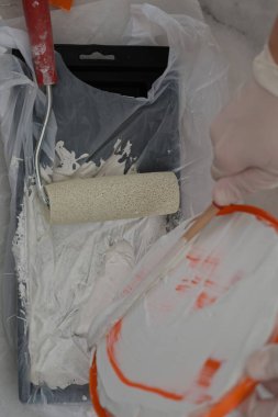 Boya fırçası tepsisi. Duvarın yüksek kaliteli 4K görüntülerini boyamak için malzemeler