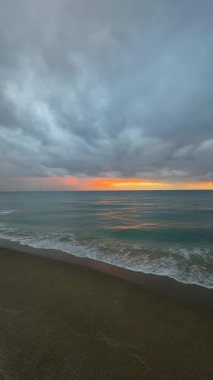 Sahilde günbatımı. çarpıcı renkli gökyüzü, deniz manzarası. Yüksek kalite 4k görüntü