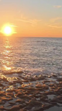 Sahilde günbatımı. çarpıcı renkli gökyüzü, deniz manzarası. Yüksek kalite 4k görüntü