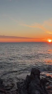 Sahilde günbatımı. çarpıcı renkli gökyüzü, deniz manzarası. Yüksek kalite 4k görüntü