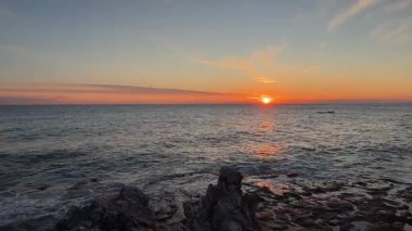 Sahilde günbatımı. çarpıcı renkli gökyüzü, deniz manzarası. Yüksek kalite 4k görüntü