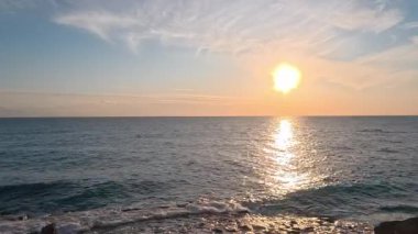 Sahilde günbatımı. çarpıcı renkli gökyüzü, deniz manzarası. Yüksek kalite 4k görüntü