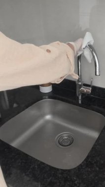 Mutfak lavabosunu temizliyorum. Eldivenli bir elin peçeteyle mutfağı silişi. Yüksek kalite 4K görüntü.