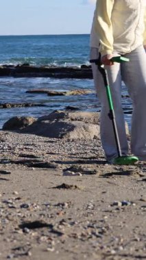 Metal detektörü araması. Plaj metali detektörü. Doğada bir metal dedektörü, soğuk mevsimde deniz manzarası. Yüksek kalite fotoğraf
