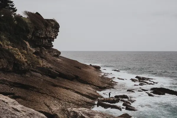 Viaggiatore in piedi sulla roccia in mare — Foto Stock