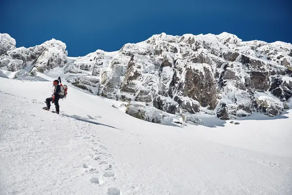 Adam karlı dağlarda hiking — Stok fotoğraf