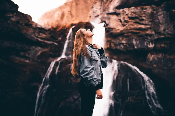 Beautiful woman near picturesque waterfall — Stock Photo, Image