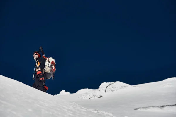 Homem caminhadas em montanhas nevadas — Fotografia de Stock