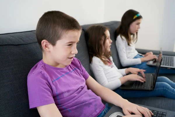 Grupo Niños Que Usan Computadoras Portátiles Mientras Están Sentados Sofá —  Fotos de Stock