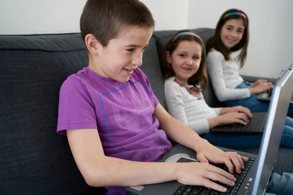 Grupo Crianças Usando Laptops Enquanto Senta Sofá Casa — Fotografia de Stock