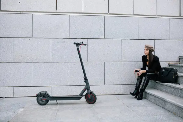 Bere Şapkalı Kadın Girişimci Şehrin Merdivenlerinde Modern Elektrikli Scooter Yanında — Stok fotoğraf