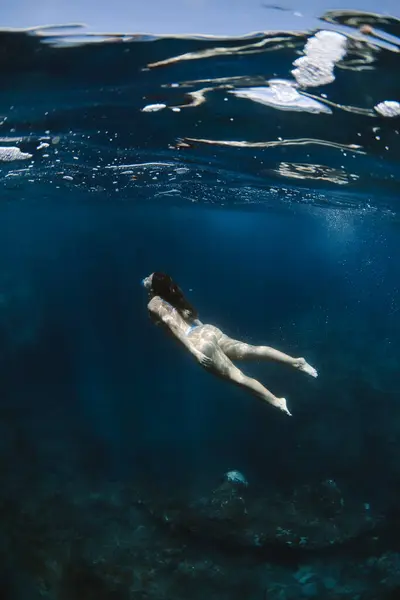 日当たりの良い熱帯リゾートで休暇中にきれいな透明海での水着水泳の女性観光客 — ストック写真