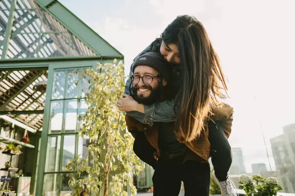 Smiling Bearded Boyfriend Piggybacking Happy Girlfriend While Having Fun Terrace — 图库照片