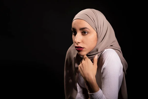 히잡에 의지하고 어두운 녹음실에서 시선을 돌리는 이슬람교도의 무어인 — 스톡 사진
