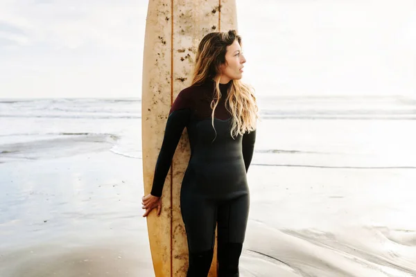 Surfer Woman Dressed Wetsuit Standing Looking Away Surfboard Beach Sunrise — Stock Photo, Image