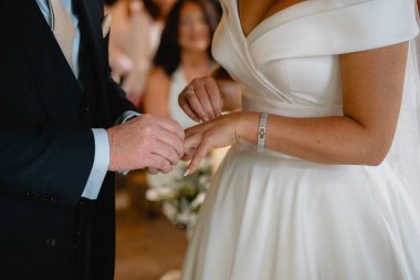 Bir erkek ve bir kadın evleniyor. Adam kadının parmağına yüzük takıyor.