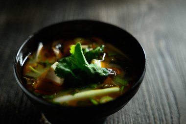 Yeşil otlu bir kase çorba. Çorba zengin, koyu renkli ve güçlü bir aroması var.