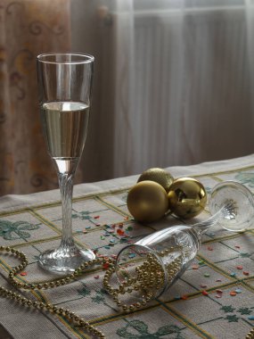 Şampanyadan arta kalan kadehler ve masaya bırakılmış yeni yıl süslemeleri..
