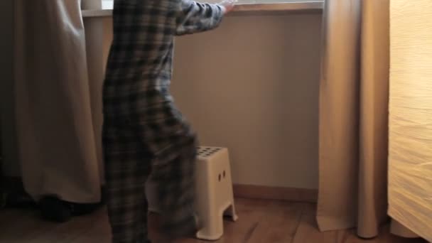 Junge schaut durch Fenster — Stockvideo