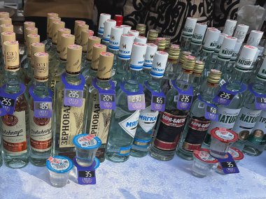 Bişkek, Kırgızistan - 19 Ekim 2025: Fuarda etiketli votka şişelerinin gösterimi. Perakende satış ve tüketici ürünü sunumu kavramı.