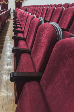 Bir sıra şık tiyatro koltuğu. Canlı performans beklentisi.