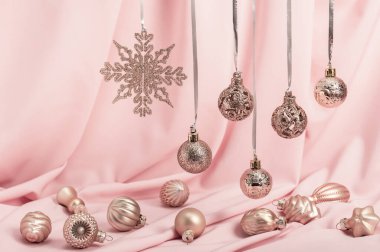 Noel arkaplanı, Noel kartı. Noel ağacı oyuncakları ve pembe arka planda asılı çelenkler. Pembe Noel.