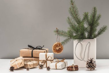 Kurumuş portakal dilimleri ve Noel hediye kutularıyla süslenmiş Firavun dalları. Yeni yıl dekorunda doğal malzemeler ve dokular, ekolojik Noel tatili. Boks Günü.