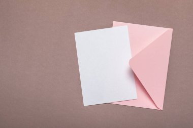 Pembe zarf ve boş form kahverengi arka planda