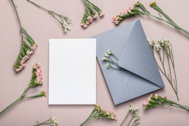 Gray envelope and blank form on a background of flowers. Greeting card.