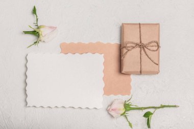 Tebrik kartı modeli, içi boş, el işi hediye kutusu ve arka planda iki beyaz gül..