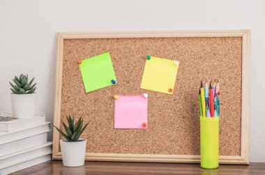 Kitapların, kalem tutacağının, çiçeklerin ve mantar mantarların olduğu çalışma alanı. Okula, üniversiteye, üniversiteye.