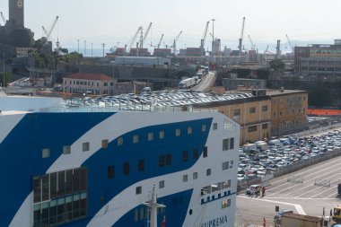 06.18.25, Genua, İtalya, sanayi limanına yanaşmış büyük bir feribotun yakın görüntüsü. Arka planda sayısız vinç ve depo var. Aktif deniz lojistiğinin atmosferini yakalıyorlar.