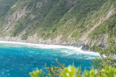 Turkuaz deniz dalgaları kayalık sahil şeridi boyunca. Yaz ve tatil duyguları ile temiz doğal seyahat geçmişi