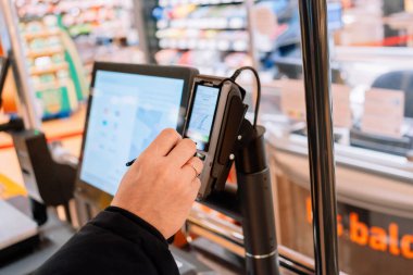 Bad Hersfeld, Almanya, 01.17.26, Müşteri süpermarkette dokunmatik ekranı kullanıyor. Dijital arayüz, perakende otomasyon, nakit ödeme ve modern tüketici davranışı kavramı