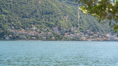 Sahil boyunca yeşil tepeleri olan sakin bir dağ gölü geniş manzaralı. Huzurlu bir atmosferi olan doğal yaz manzarası. Doğa, seyahat ve sükunet kavramı.