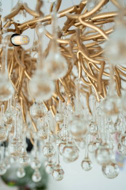 Kristal avize detaylarının dikey yakın çekimi. İç tasarım ve modern dekor kavramları için şık lüks ışıklandırma ögesi