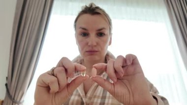 Tek tek takviye yutan ve su içen bir kız. Günlük sağlık alışkanlıklarının ve önleyici alışkanlıkların sembolü.