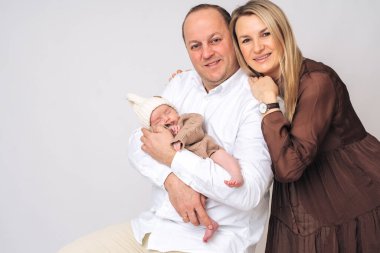 Yeni doğmuş bebekle mutlu bir ailenin stüdyo portresi. Ebeveynlik, çocuk bakımı ve aile yaşam tarzı kavramları için mükemmel..