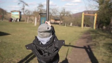 Çocuk oyun parkına tırmanıyor ve parkın karşısına geçiyor. Çocuk oyun parkı ekipmanlarıyla aktif açık hava oyunu. Çocukluk eğlencesi, macera ve sağlıklı açık hava aktivitesi kavramı.