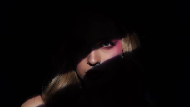 Model yang indah dengan makeup cerah dan bibir merah. Potret seorang gadis close-up di latar belakang biru. — Stok Video