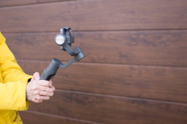 Akıllı telefonlar için dengeleyici tutan bir adam. Sokakta cep telefonu sesleri..