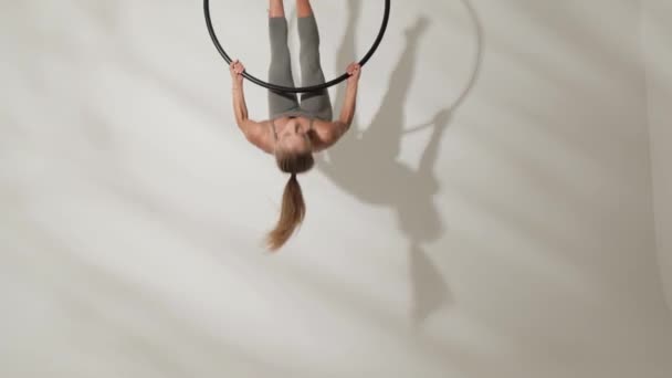 Girl gymnast on an acrobatic ring on a white background with shadows. — Stock Video