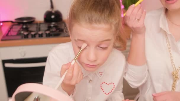 Moeder en haar dochter maken elkaar met cosmetica, blozen, oogschaduwen en penselen — Stockvideo